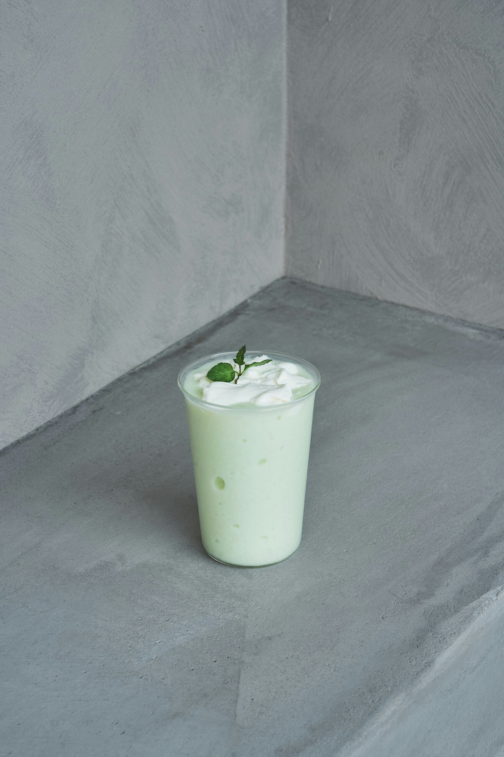 green dessert drink in front of gray backgorund